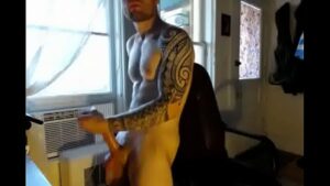 Homem sarado e tatuado se exibindo na webcam