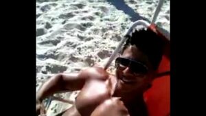 Negro gay tomando sol na praia