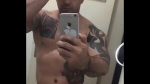 Ator gay musculoso com braço tatuado