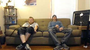 Gay guys sitting on couch cumming